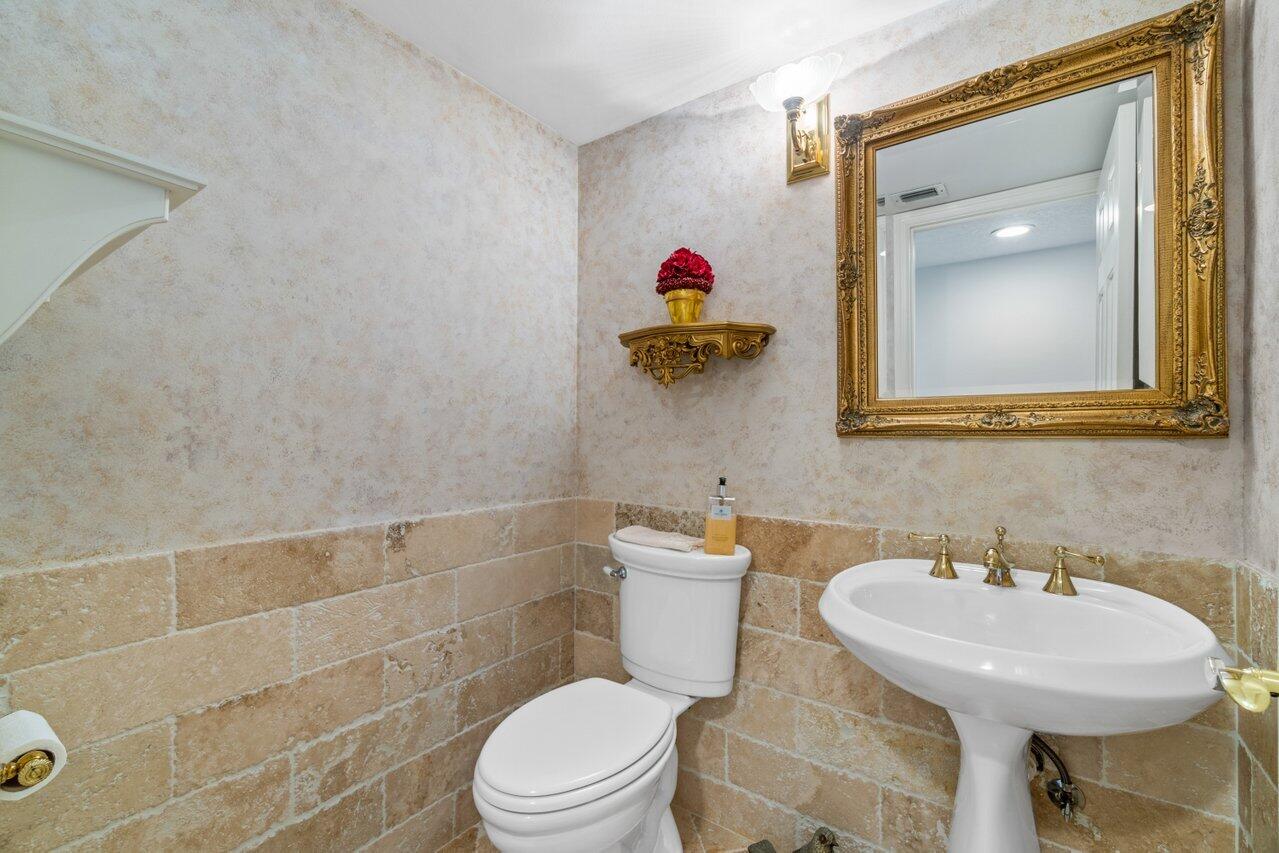 1401 South Ocean Boulevard, Unit 3090 Boca Raton, FL 33432 - Photo 10 of 46 a bathroom with a toilet sink and mirror
