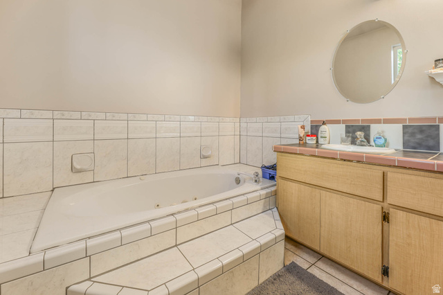 569 Elk Meadow Loop Tooele, UT 84074 - Photo 41 of 56 Bathroom with vanity, a whirlpool tub, and light tile patterned floors