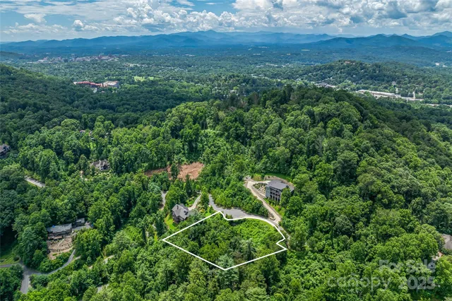 an aerial view of residential house with outdoor space and trees all around