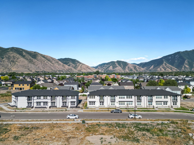 717 South Harrison Drive West Springville, UT 84663 - Photo 25 of 31 Modern multi-story residential buildings featuring white exteriors and dark roofing, situated along a paved road