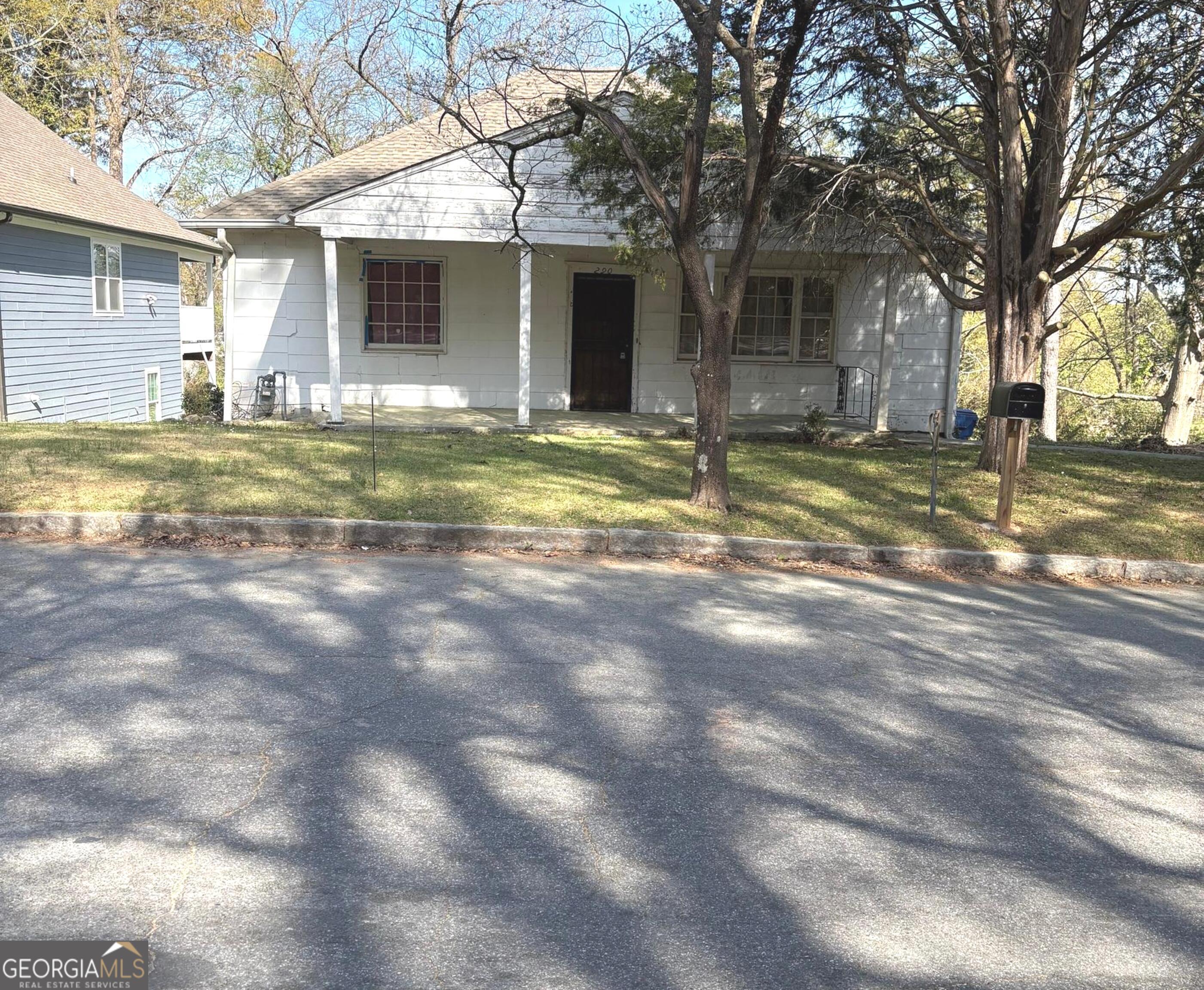 a view of a house with backyard and tree