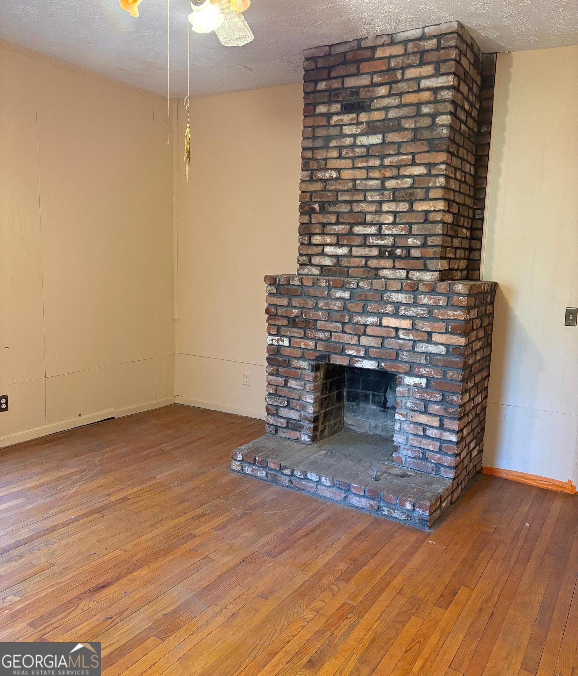 290 Florida Avenue Southwest Atlanta, GA 30310 - Photo 6 of 12 a view of empty room with wooden floor fireplace and a window