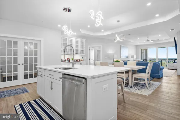 a kitchen with a refrigerator a stove and white cabinets with wooden floor