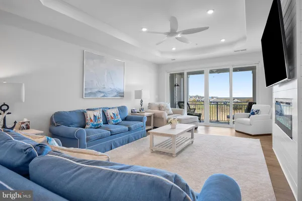 a living room with furniture a flat screen tv and a floor to ceiling window