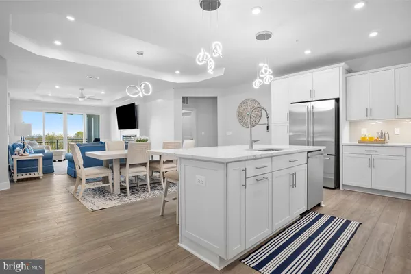 a kitchen with a dining table chairs cabinets and stainless steel appliances