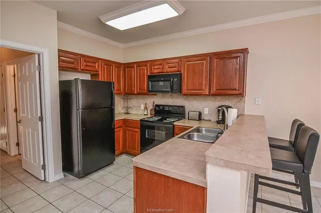 a kitchen with stainless steel appliances granite countertop a refrigerator stove microwave and sink