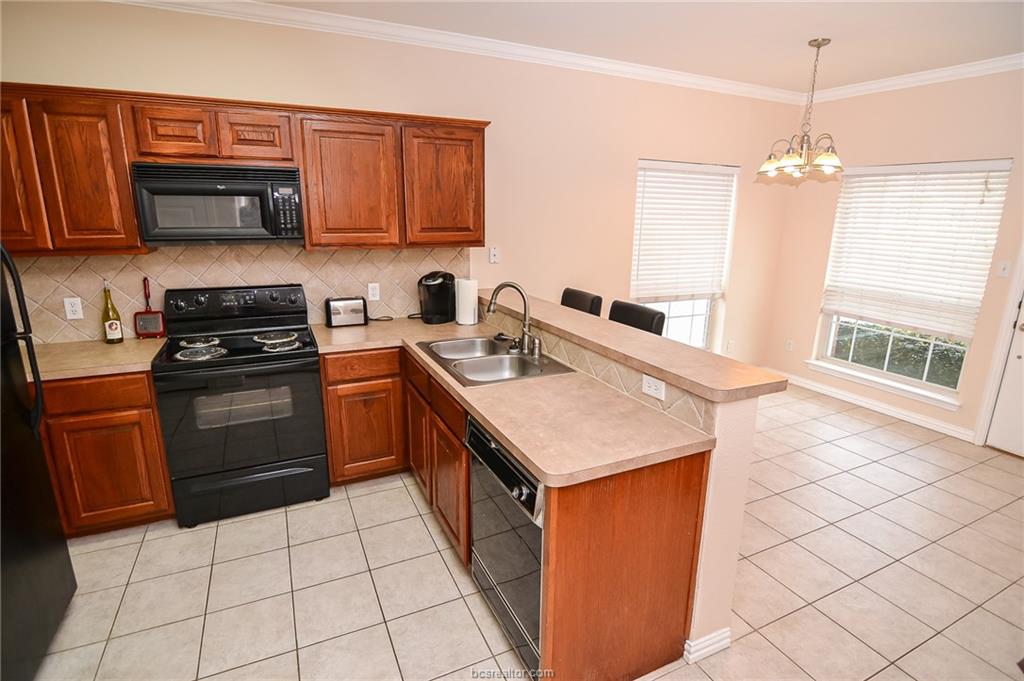 1001 Krenek Tap Road, Unit 902 College Station, TX 77840 - Photo 3 of 8 a kitchen with a sink a stove top oven and white cabinets