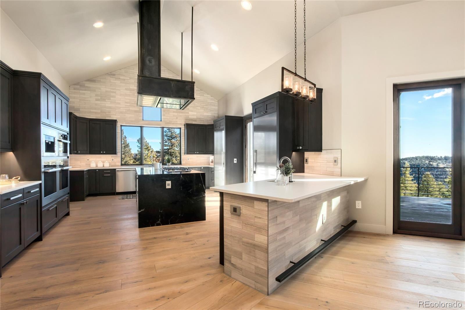 6135 Northway Drive Morrison, CO 80465 - Photo 16 of 40 a large kitchen with stainless steel appliances kitchen island granite countertop a large counter top a sink a stove and a refrigerator