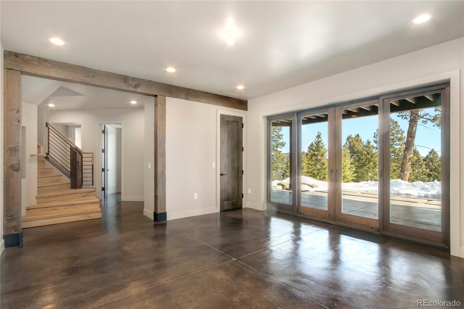 6135 Northway Drive Morrison, CO 80465 - Photo 30 of 40 an empty room with wooden floor and windows with curtains