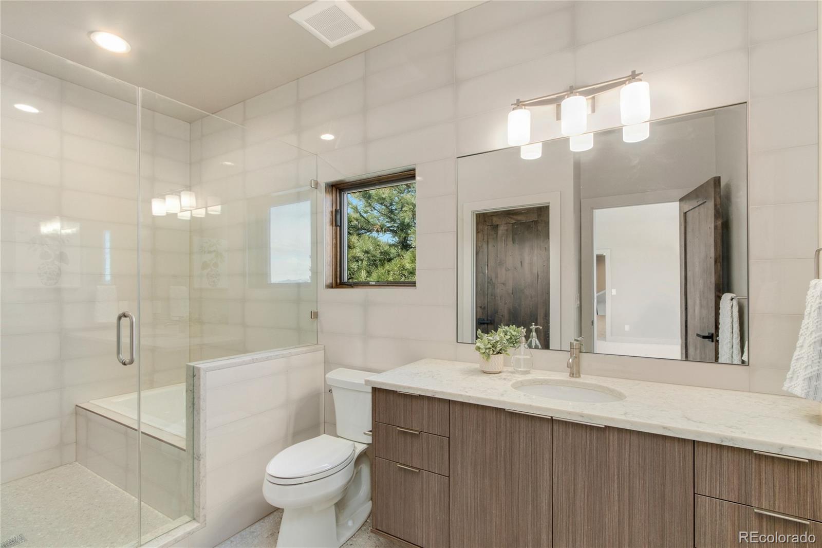 6135 Northway Drive Morrison, CO 80465 - Photo 32 of 40 a bathroom with a sink a toilet and a large mirror