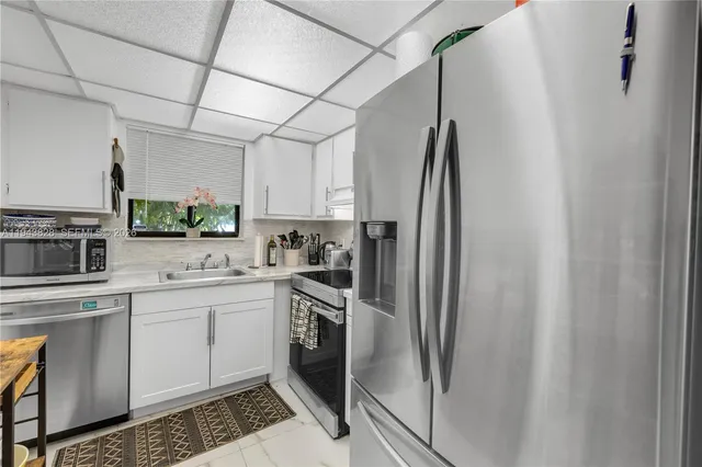 a kitchen with stainless steel appliances a refrigerator sink and microwave