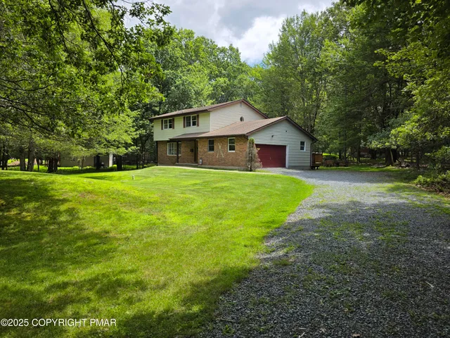 a front view of a house with yard and green space