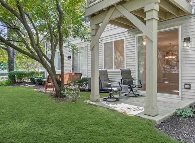 a backyard of a house with table and chairs