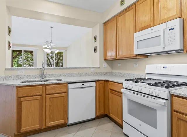 a kitchen with granite countertop stainless steel appliances white cabinets granite counter tops and a wooden floors