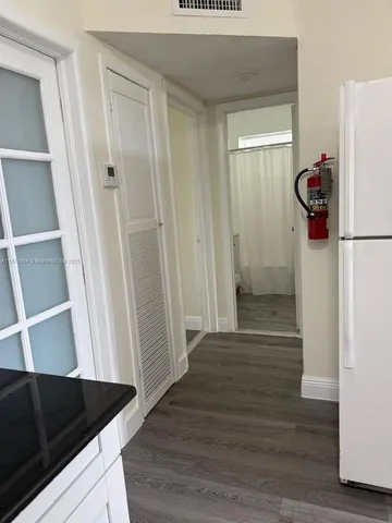 an empty room with wooden floor and mirror