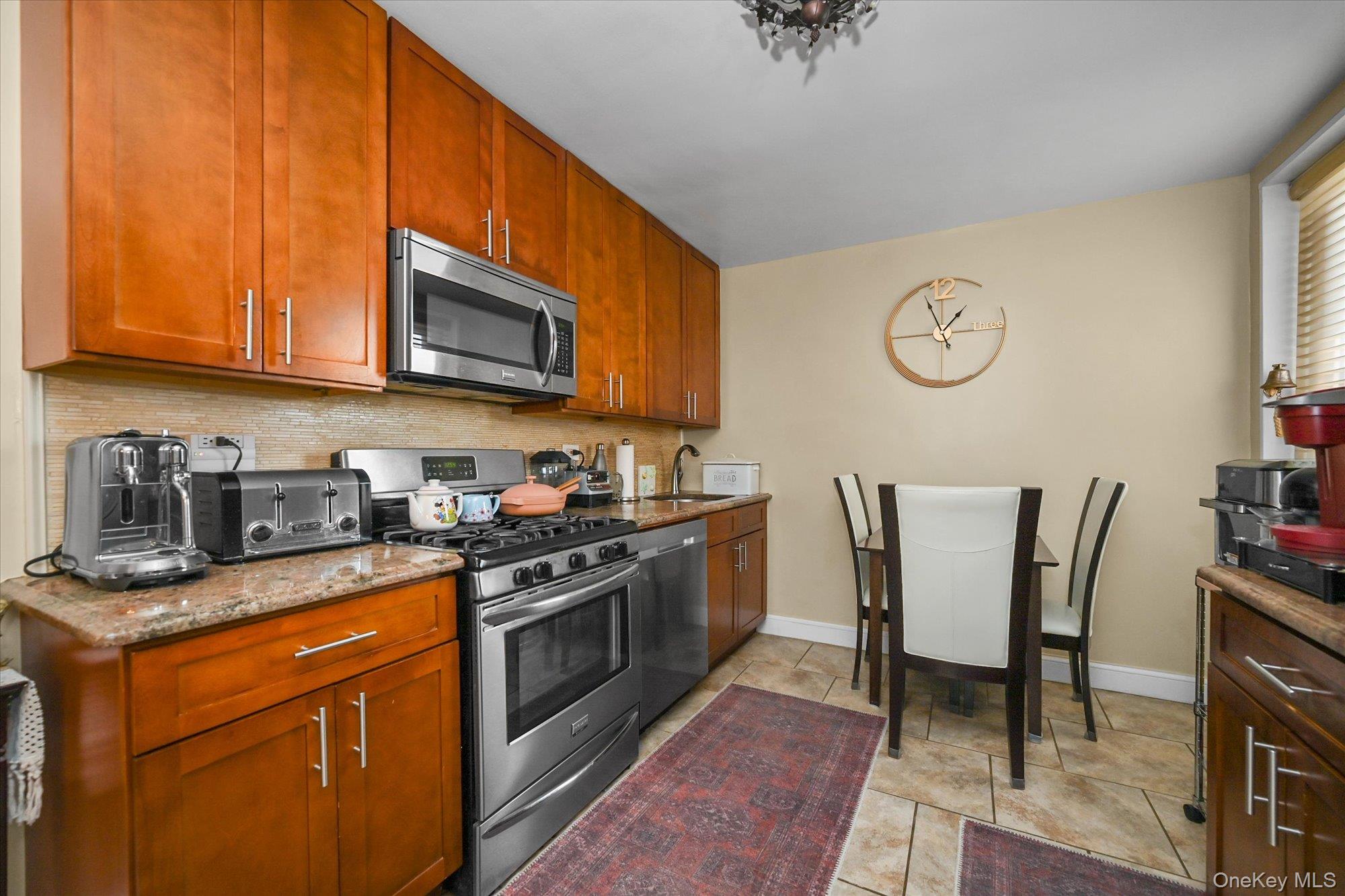 211-40 18th Avenue, Unit 4A Queens, NY 11360 - Photo 8 of 21 a kitchen with stainless steel appliances granite countertop a stove a sink dishwasher and cabinets with wooden floor