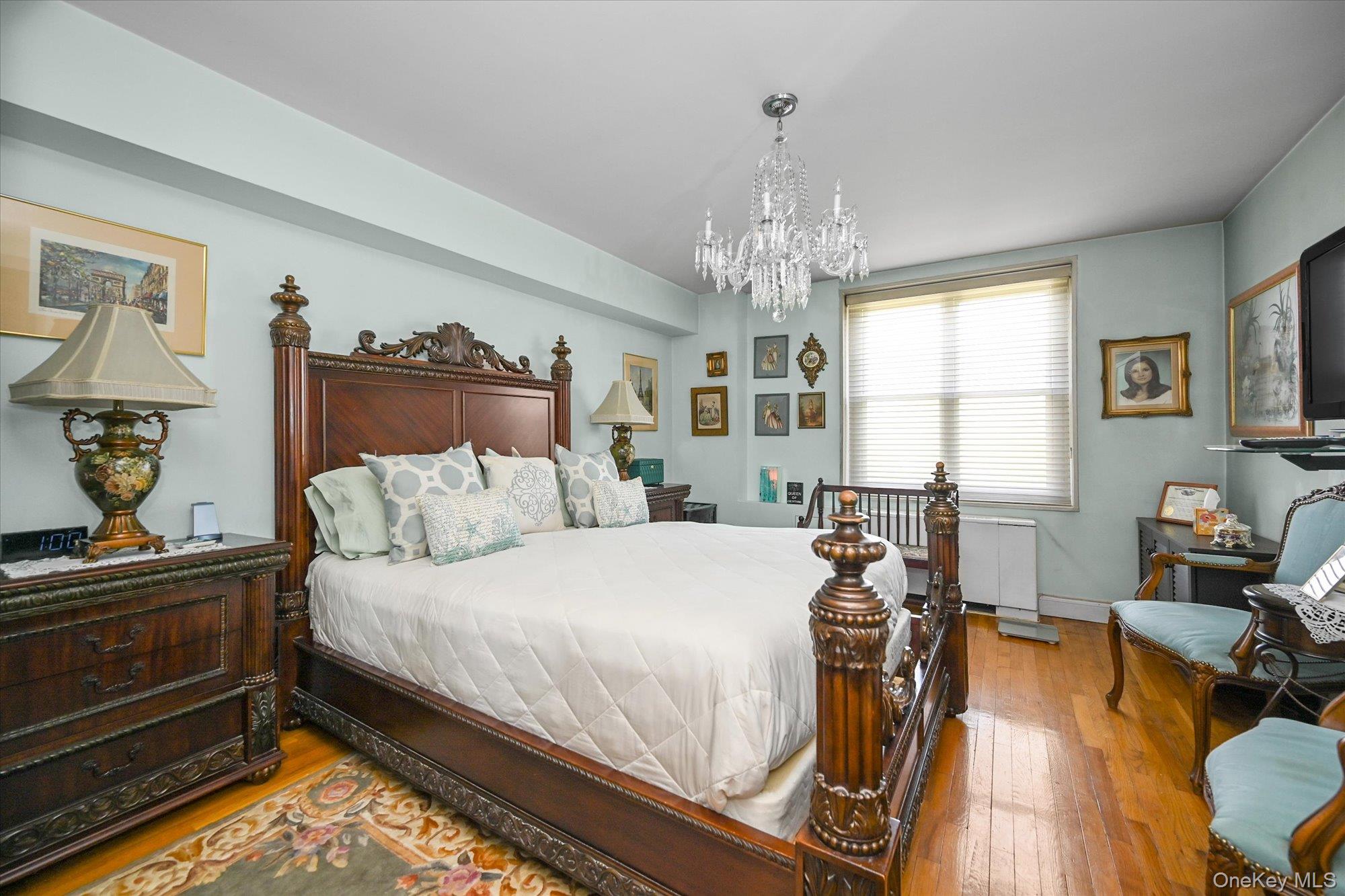 211-40 18th Avenue, Unit 4A Queens, NY 11360 - Photo 9 of 21 a bedroom with a bed and wooden floor