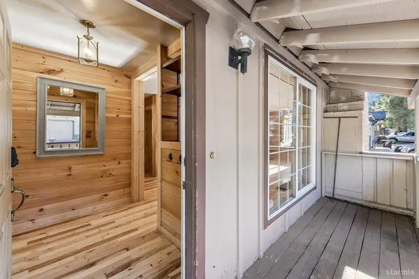 a view of a porch with wooden floor and windows