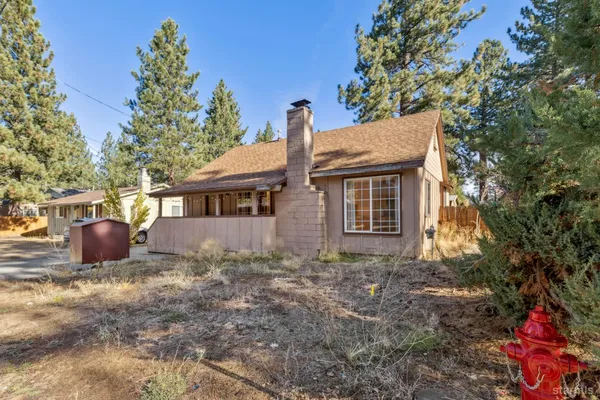 a view of a house with backyard and a tree