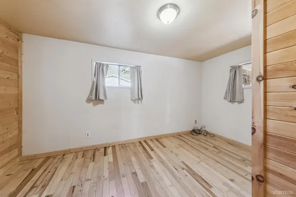 a view of a room with wooden floor and a window