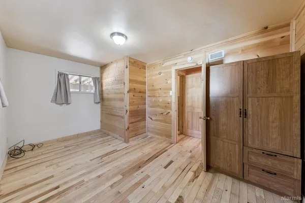 a view of empty room with wooden floor