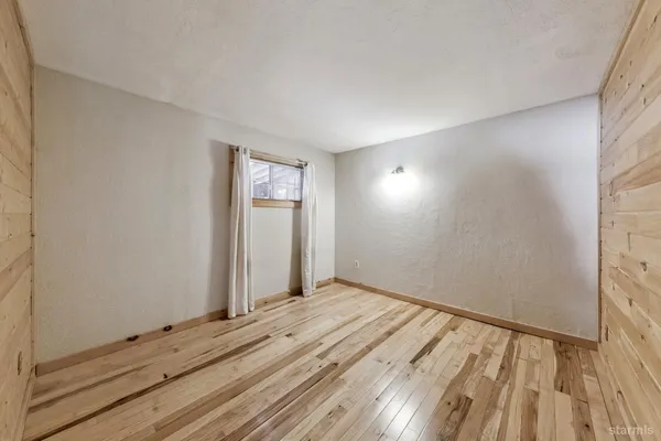 a view of empty room with wooden floor