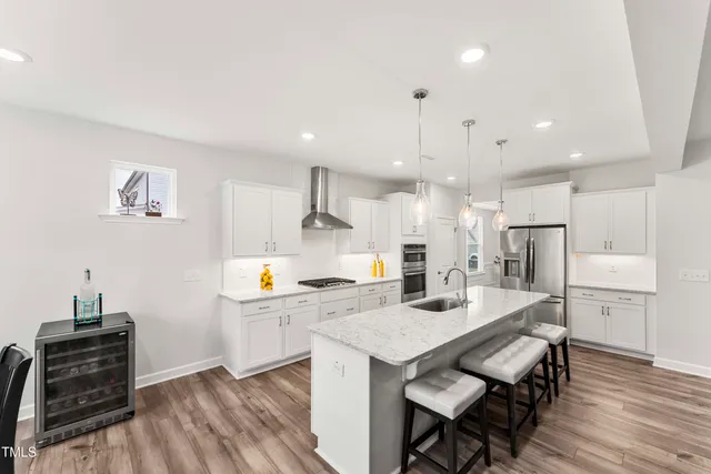 a kitchen with a table chairs refrigerator and microwave