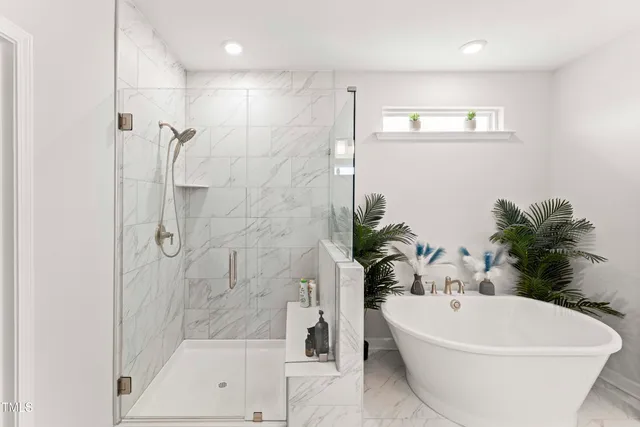 a white bath tub sitting next to a white wall