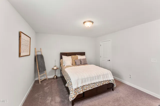 a bedroom with a bed lamp and a desk