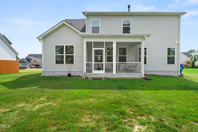 a view of a house with a big yard and large trees
