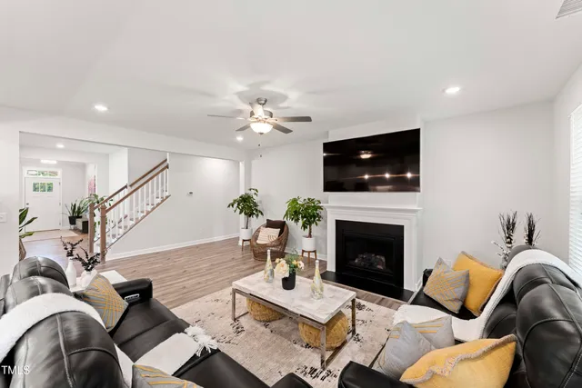 a living room with furniture a fireplace and a flat screen tv