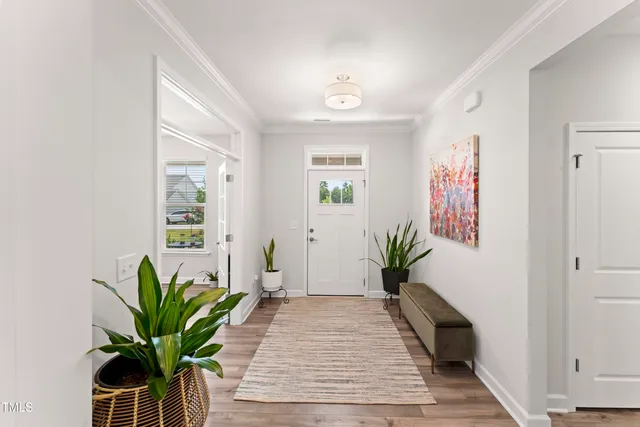 a view of a hallway with wooden floor and a potted plant