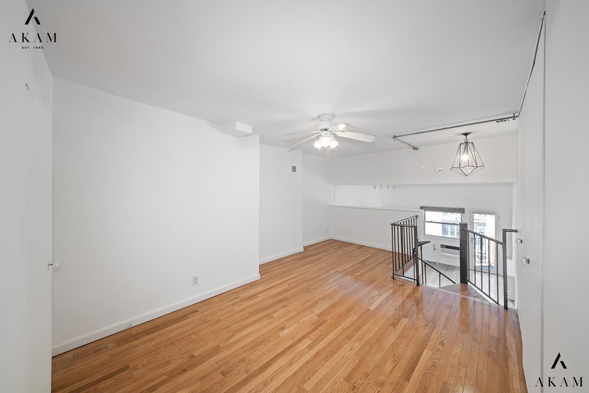 211 Thompson Street, Unit 4C Manhattan, NY 10012 - Photo 6 of 15 wooden floor in an empty room with a window