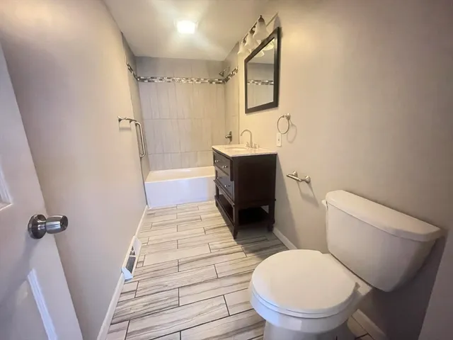a bathroom with a toilet a sink and mirror