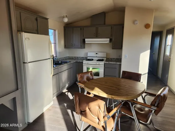 a kitchen with stainless steel appliances granite countertop a refrigerator a stove a sink a table and chairs