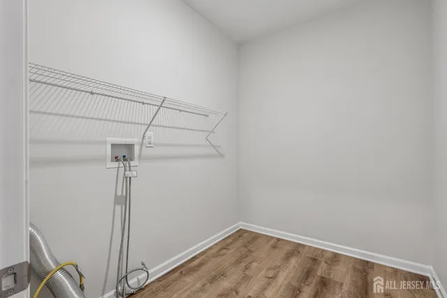 a view of a room with wooden floor and a bathroom