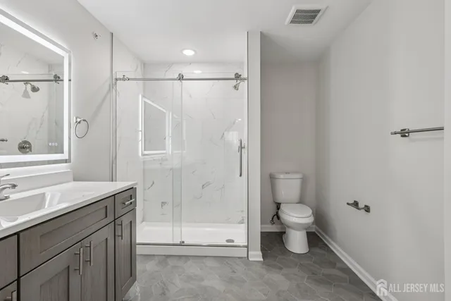 a bathroom with a sink a toilet and shower