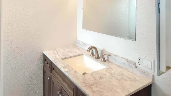 a bathroom with a granite countertop sink and a mirror
