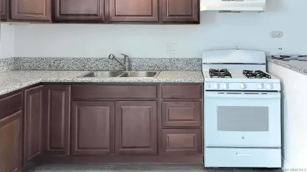 a kitchen with granite countertop cabinets stainless steel appliances and sink