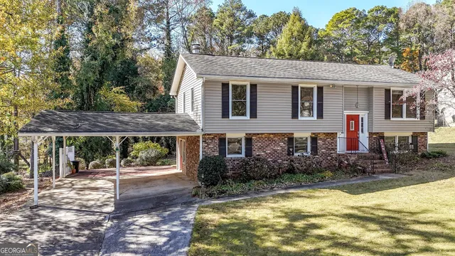 a front view of house with yard and trees around