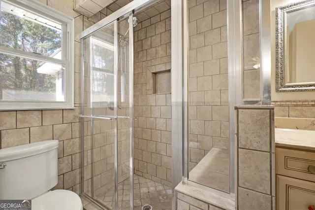 a bathroom with a granite countertop sink toilet and shower