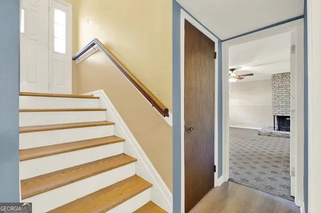 an empty room with windows and fireplace