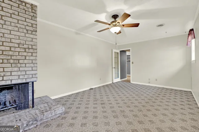 an empty room with a window and a fan