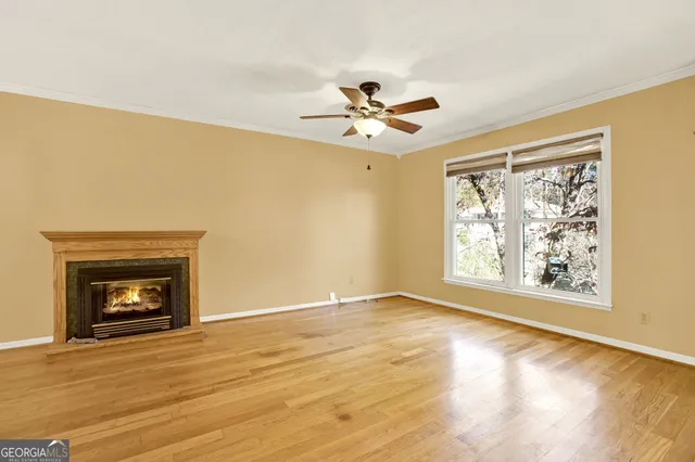 a view of an empty room with a window and fireplace