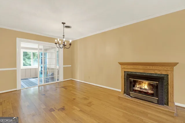 a view of an empty room with a fireplace and wooden floor