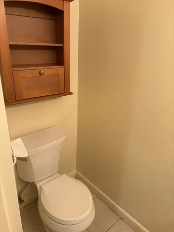a white toilet sitting next to a shower