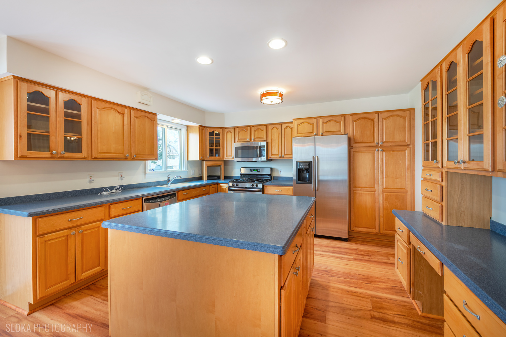 508 Crest Drive Cary, IL 60013 - Photo 9 of 35 a view of a kitchen with stainless steel appliances granite countertop a stove a sink a refrigerator and blue cabinets with wooden floor