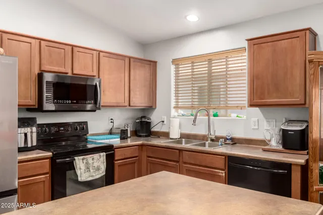 a kitchen with stainless steel appliances granite countertop a stove sink microwave and refrigerator