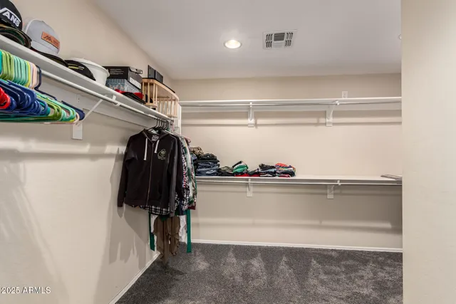 a view of walk in closet with clothes and shoes