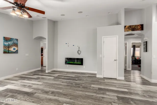 a view of a livingroom with wooden floor and a ceiling fan
